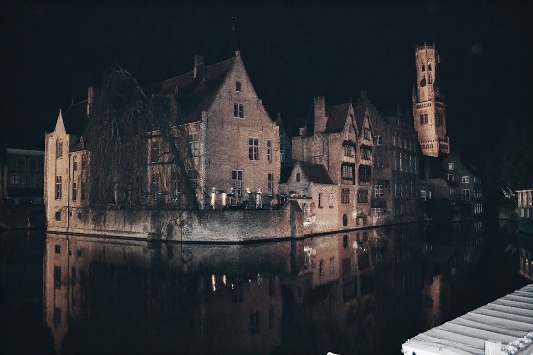 Foggy canal in Brugge at night with reflections of old buildings