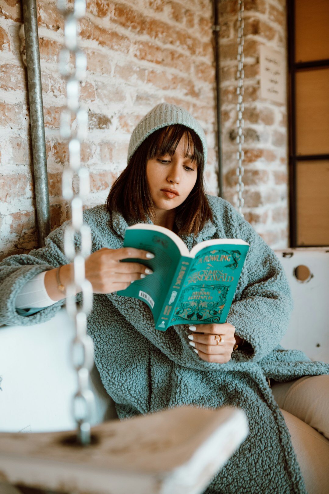 woman reading detective novel in cozy chair