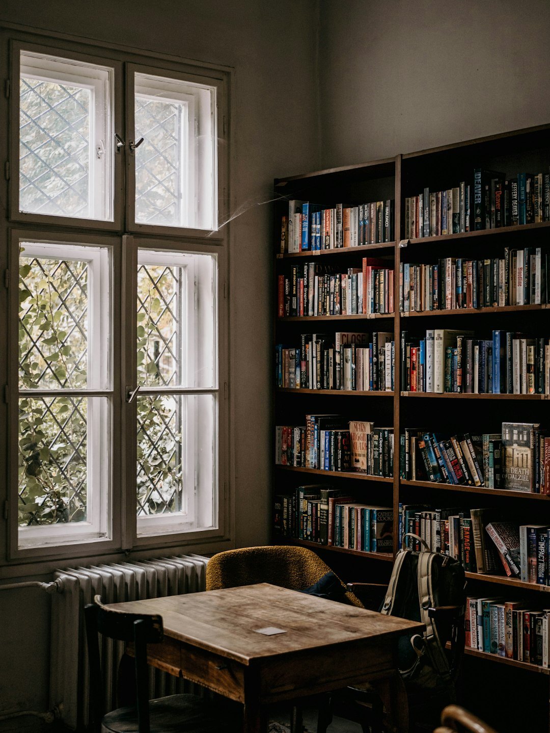 Old wood-panelled library with tall bookshelves full of crime novels