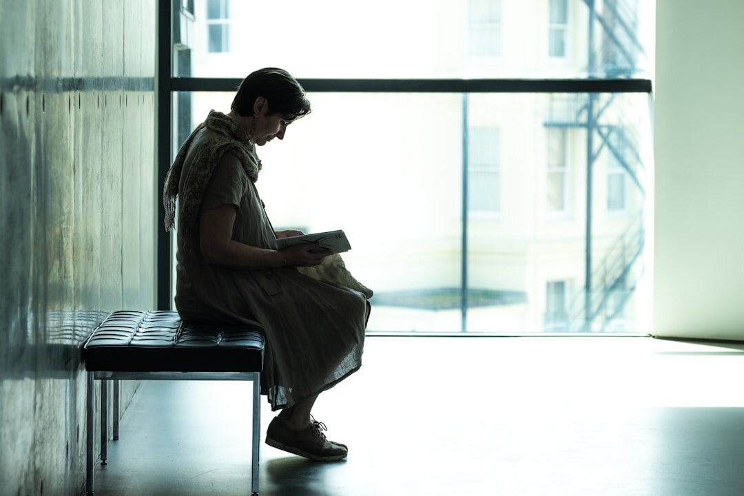woman reading mystery book by window